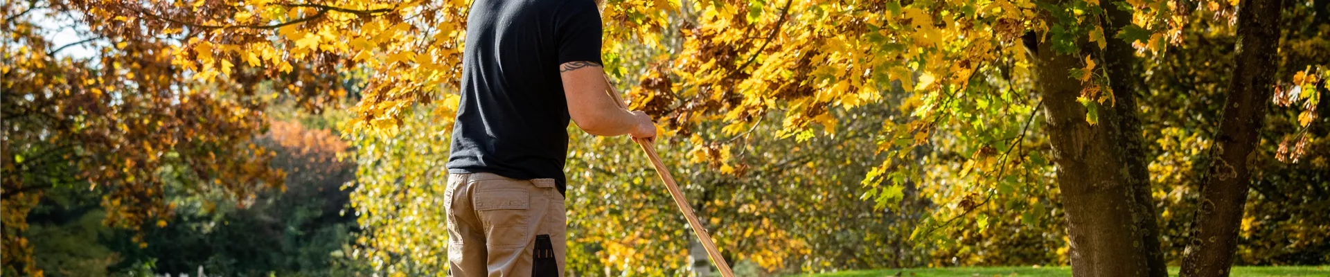 Gartengeräte - Mann harkt Laub
